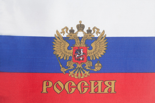 Russian flag with emblem of Russia background close up.