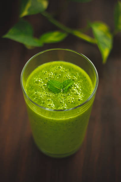 istock Healthy green juice on a table with plants 970938010