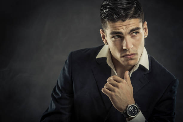Portrait of a young fashion model with a hand watch. About 25 years old Caucasian male in suit.