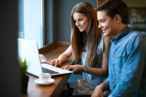 istock Beautiful Couple Working On Notebook In Cafe. 970947890
