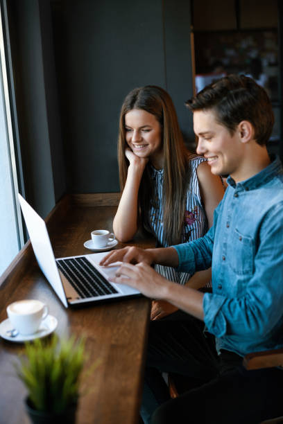 istock Beautiful Couple Working On Notebook In Cafe. 970947998