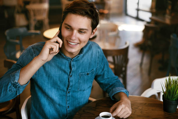 istock Man Talking On Phone And Drinking Coffee In Cafe. 970952290