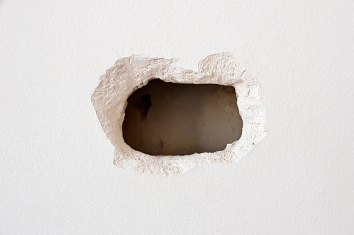 hole in a white wall inside a home