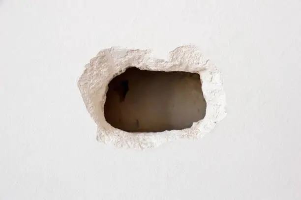 hole in a white wall inside a home