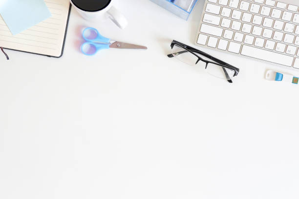 istock Workspace office desk computer, notebook paper, glasses, cup of coffee and scissors on white table. 970957458