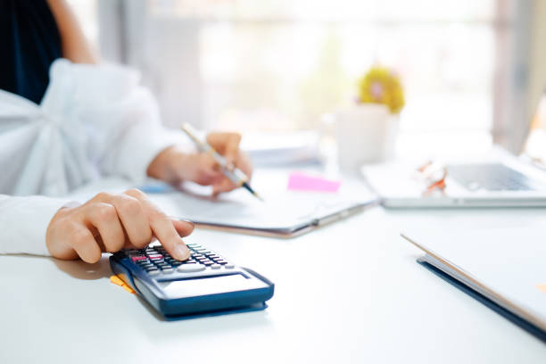 istock Closeup woman calculate finance data with calculator on office table with morning light. 970961186