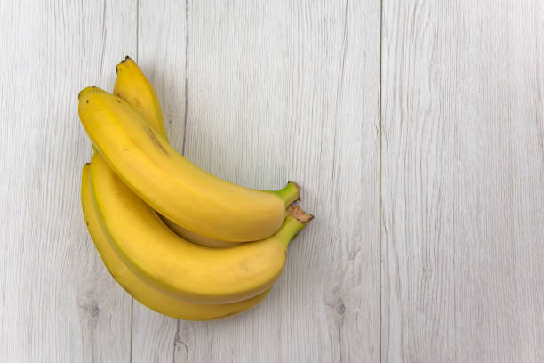 istock Bananas on white wood table, top view 970975124