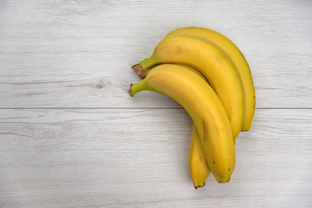 istock Bananas on white wood table, top view 970975160