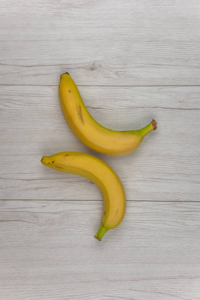istock Bananas on white wood table, top view 970975234