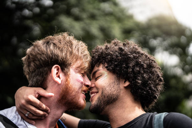 momento de cariño de pareja gay en desfile del orgullo gay - gay man homosexual men kissing fotografías e imágenes de stock
