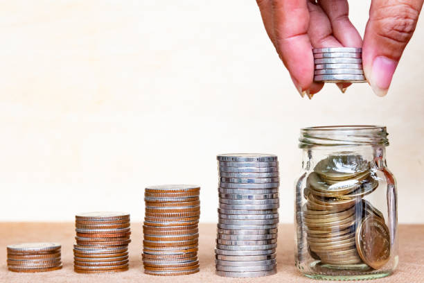 istock Saving money concept. Close up hold stack coins to arrange inger hold stack coins into bottle arrangement with shown concept of growing business and wealthy. 970984742
