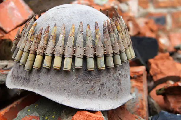 Old rusty military helmet and machine gun belt with cartridges