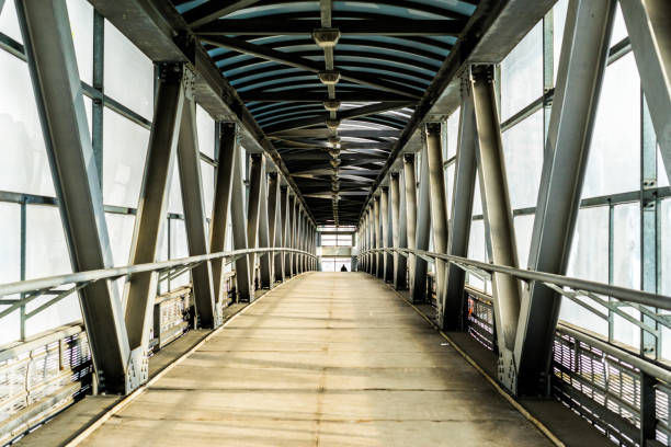 istock Modern overhead passage from steel and glass, perspective, long tunnel in sunset light 970994682
