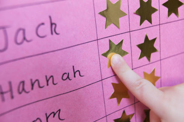 Close Up Of Child With Reward Chart Close Up Of Child With Reward Chart incentive stock pictures, royalty-free photos & images