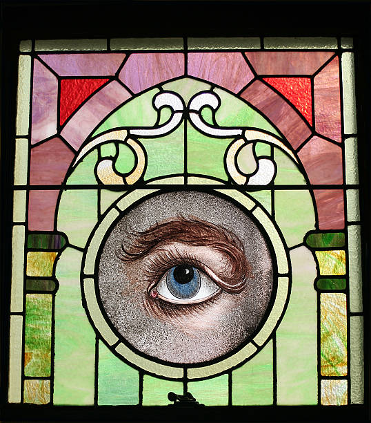 A detail from a stained glass window in an old church which features a blue eye close-up.  This church just has its 300 year anniversary.  
