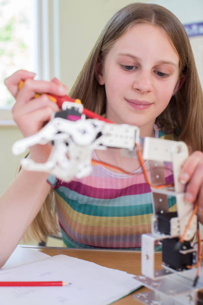 istock Female Pupil In Science Lesson Studying Robotics 971001130