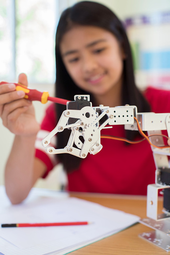 Female Pupil In Science Lesson Studying Robotics