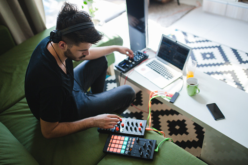 Young Man Enjoys Producing Music In Comfort Of living Room