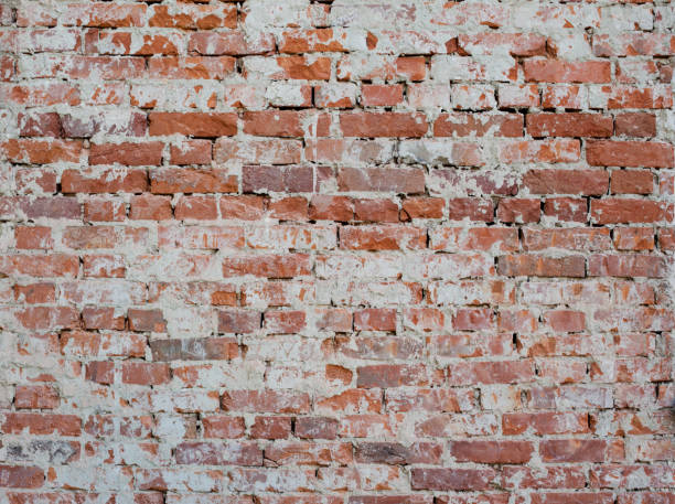 istock Old vintage red brick wall with sprinkled white plaster texture background 971004884
