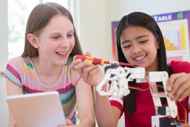 two female pupils in science lesson studying robotics - mathematics elementary student child student imagens e fotografias de stock