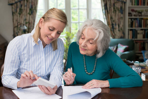 istock Woman Helping Senior Neighbor With Paperwork 971008570