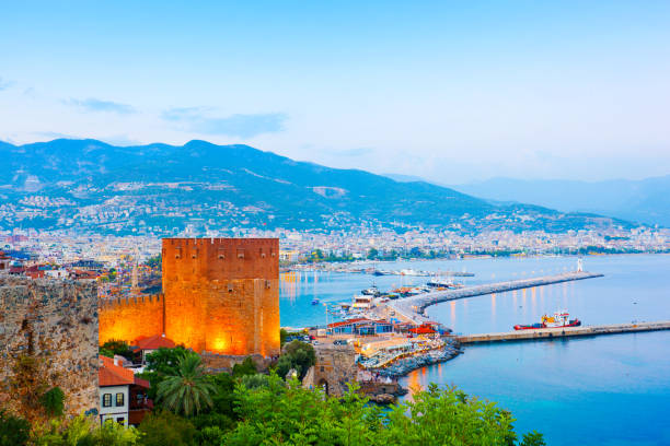 blick auf alanya und hafen bei sonnenuntergang - stone water sea mediterranean sea stock-fotos und bilder