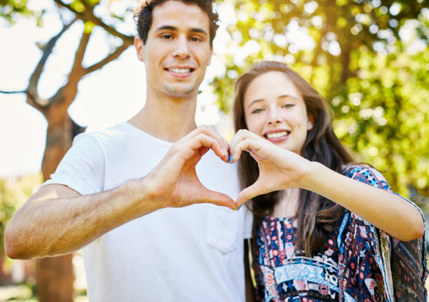istock Young couple in love make heart shape with hands, smiling 971011958