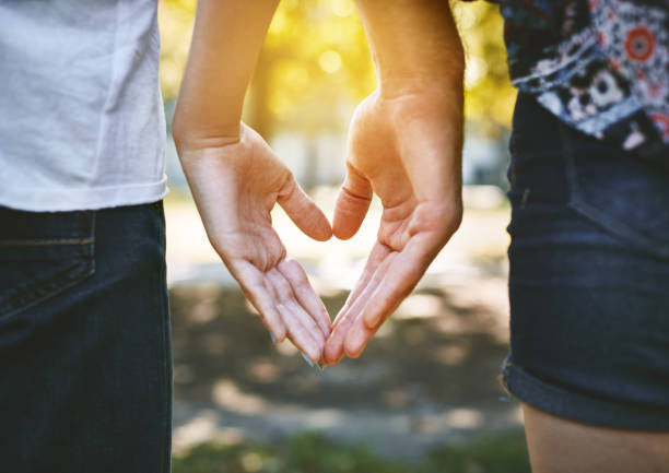 istock Rear view of couple making heart shape with hands 971018866
