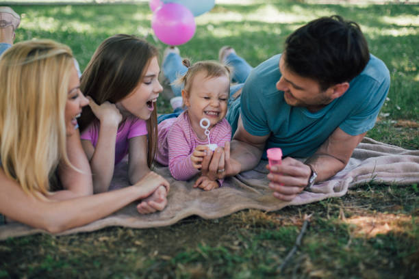 istock Man handing bubble wand to his daughters 971021874