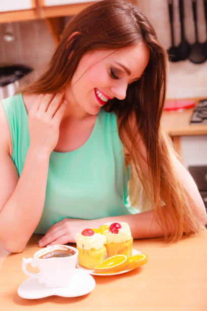 istock Woman with coffee cup cupcake in kitchen 971043202