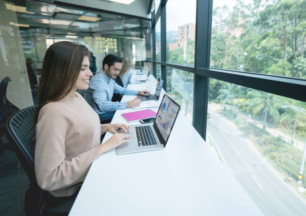 istock Happy group of people working online at a co-working space 971043726