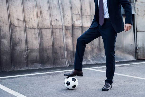 vista parcial del empresario en juego jugando al fútbol en la calle - suit soccer men sport fotografías e imágenes de stock