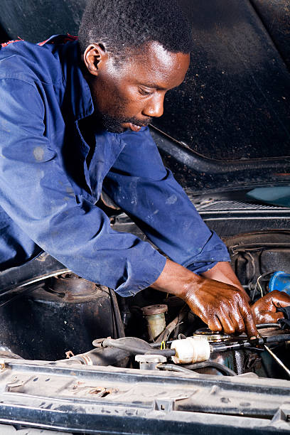 africmechanic trabalhar com um carro quebrado para baixo - old men car vertical imagens e fotografias de stock