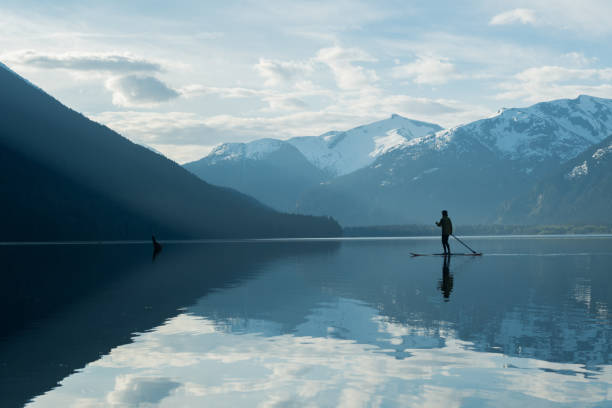 istock Woman stand up paddle boarding on a pristine mountain lake 971053008