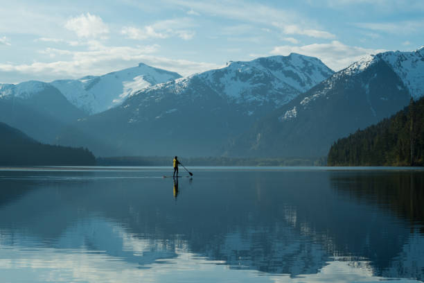 istock Woman stand up paddle boarding on a pristine mountain lake 971053054