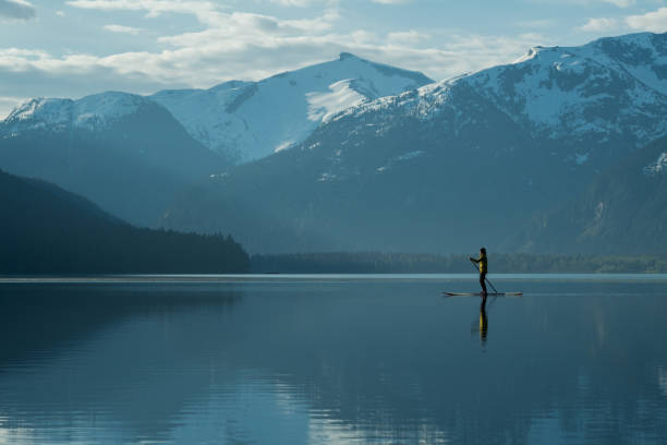 istock Woman stand up paddle boarding on a pristine mountain lake 971053124
