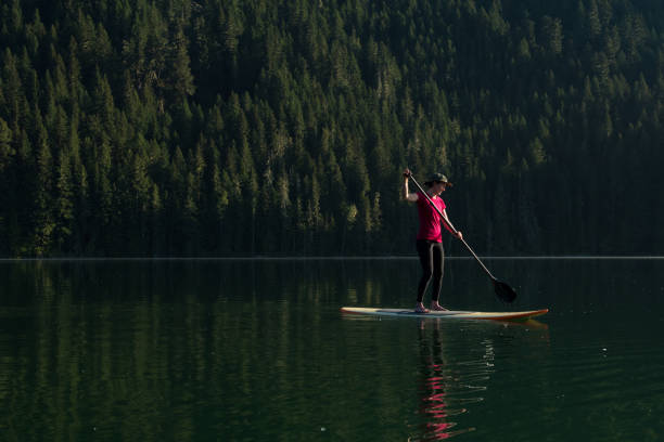 istock Woman stand up paddle boarding on a pristine mountain lake 971053128
