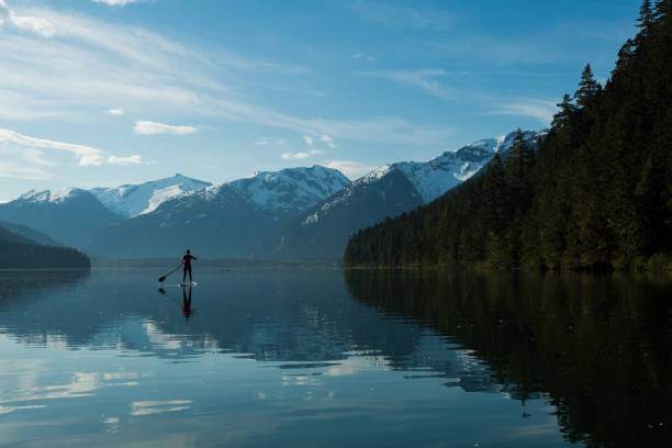 istock Woman stand up paddle boarding on a pristine mountain lake 971053330