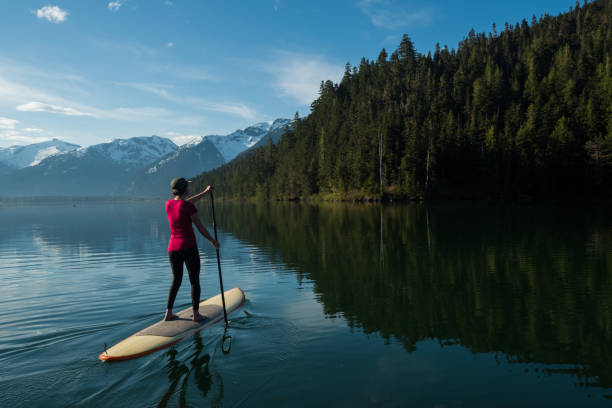 istock Woman stand up paddle boarding on a pristine mountain lake 971053392