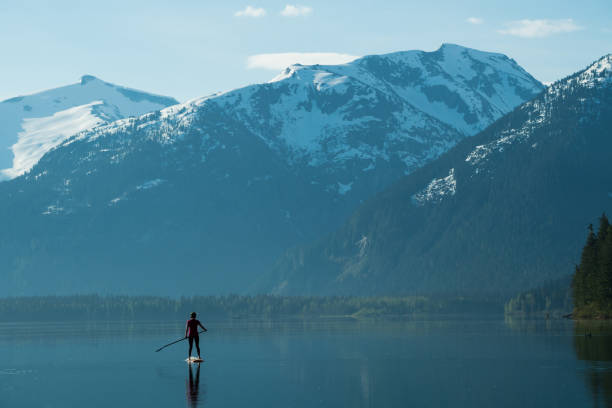 istock Woman stand up paddle boarding on a pristine mountain lake 971053464