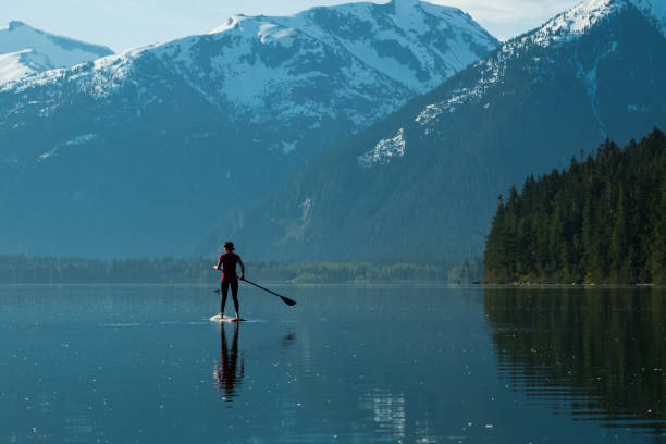 istock Woman stand up paddle boarding on a pristine mountain lake 971053486