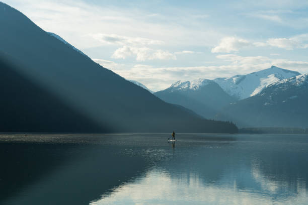 istock Woman stand up paddle boarding on a pristine mountain lake 971053576