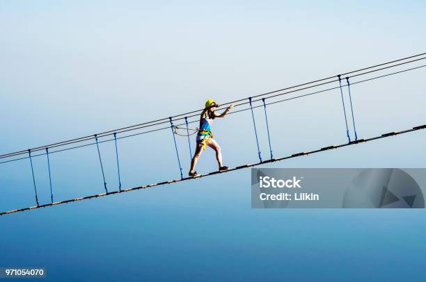 Photo libre de droit de Femme Sur Le Pont De Corde De Pendaison banque d'images et plus d'images libres de droit de Bleu - Bleu, Corde, Escalade