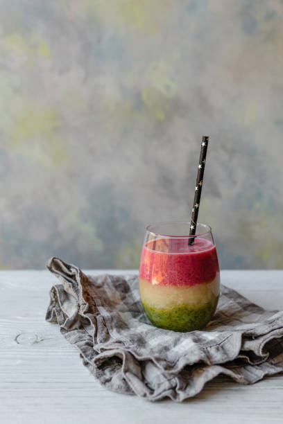 Fresh healthy layered smoothie on rustic table