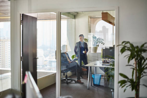 istock Professional with coworker seen through glass 971057450