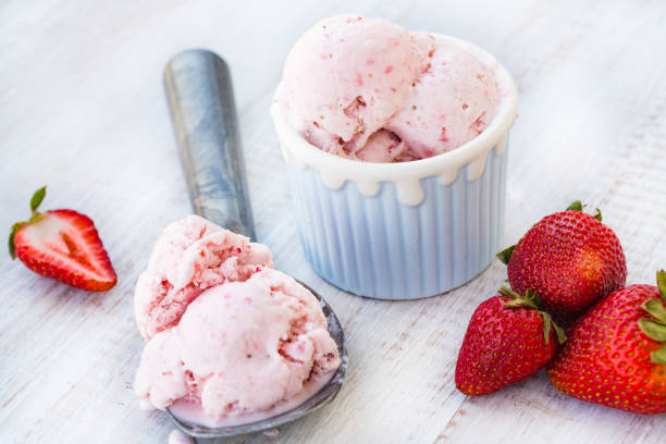 Strawberry Ice Cream With Fruit In a Bowl and Scooper stock photo