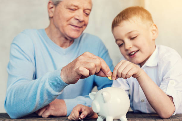 istock Concentrated relatives putting a coin into a moneybox 971067110
