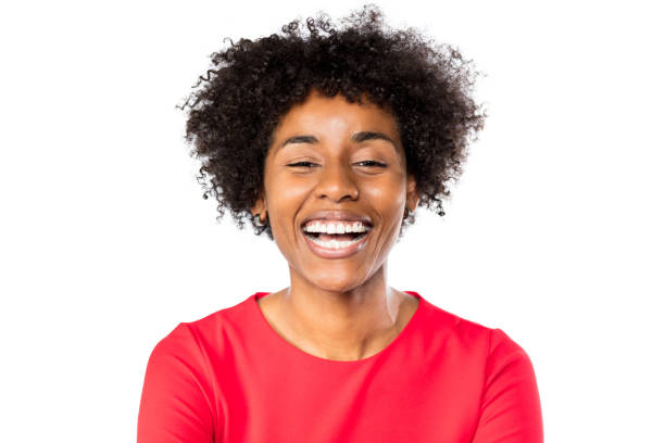 Close up portrait of cheerful young woman laughing against white background. Excited young african female in casuals.