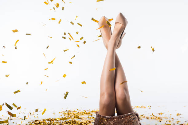 istock cropped image of woman lying with legs up under falling confetti on white 971070232