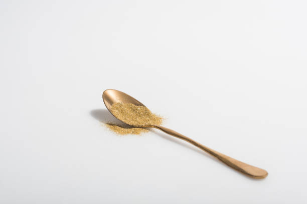 istock golden spoon and bright glitter on white surface 971070800